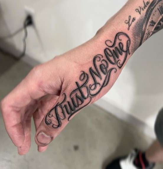 Trust No One Tattoo on finger