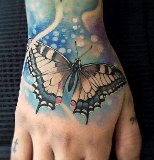 Colorful whimsical butterfly tattoo hand