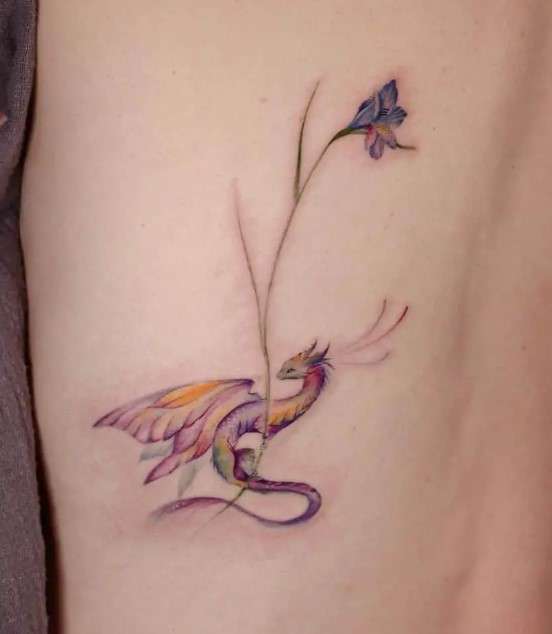 Whimsical Dragon carrying flower tattoo