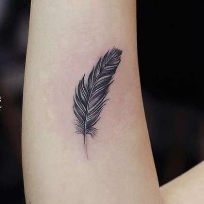Whimsical feather tattoo hand