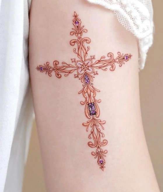 Whimsical golden Cross tattoo